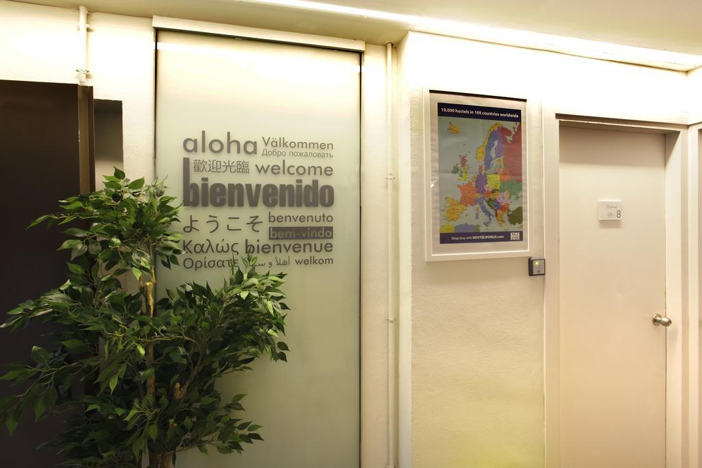 Gracia City Hostel Barcelona Exterior foto Aloha written in several languages at the entrance of a hotel in Geneva